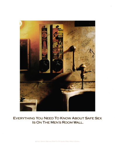 Condom dispensers hang on the wall of a dingy men's room