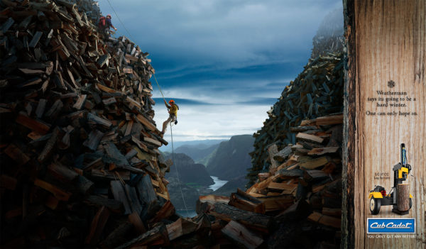 A mountain climber rappels down a cliff made of split wood